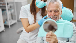 Hombre mayor sonriendo tras su tratamiento de implantología dental